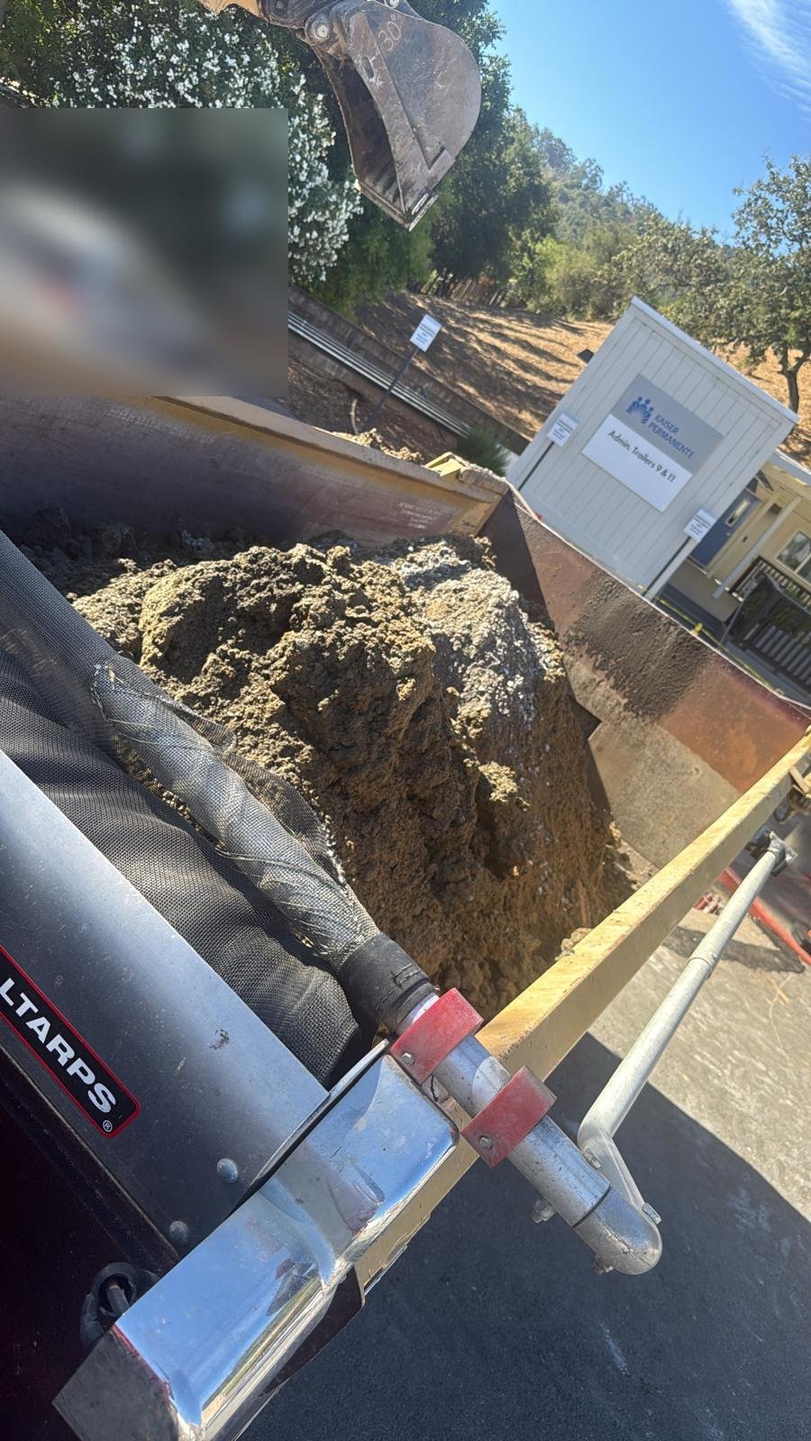 Excavator loading dirt into a Dirt Haulers trailer